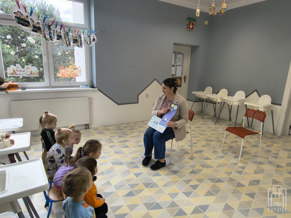 Biblioteka Gorlice, Cała Polska czyta dzieciom bibliotekarka prezentuje dzieciom rozkładane ilustracje w książce